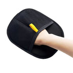 Black pet hair removal glove worn on a hand