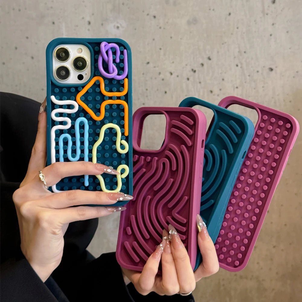 Πράσινη και κόκκινες θήκες iPhone με σχέδια λαβυρίνθου στα χέρια