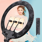 Γυναίκα μπροστά σε ring light με θέσεις για πολλά κινητά και τηλεχειριστήριο