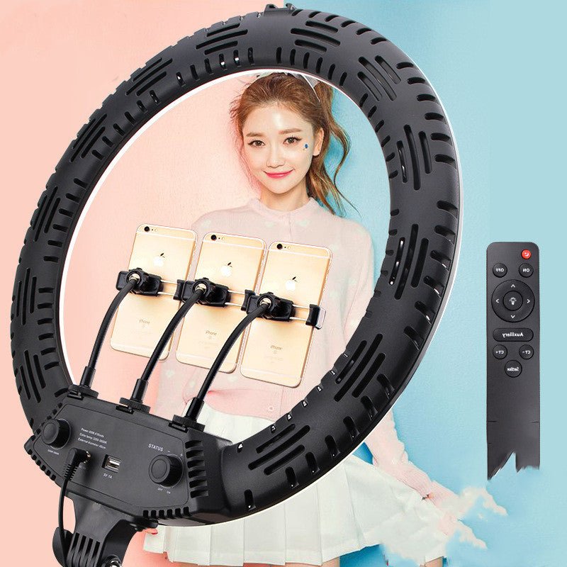 Γυναίκα μπροστά σε ring light με θέσεις για πολλά κινητά και τηλεχειριστήριο