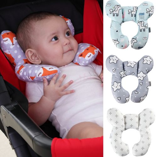 Baby in a stroller with a U-shaped head support pillow, next to a collection of prints Main image